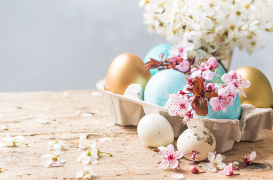 Easter holiday background, greeting card.Easter colored eggs and spring flowers on rustic wooden table background copy space.