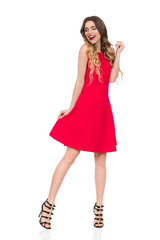 Happy Young Woman In Red Dress And High Heels Is Looking Away