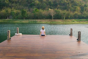 Fototapeta na wymiar A woman relaxing on pier in Garda Lake for background image.