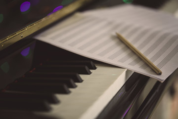 Compose Concept. Pencil and sheet music on the piano keyboard