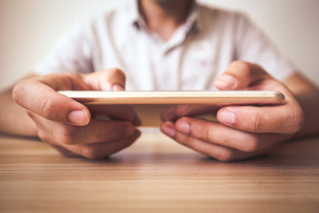 Man playing smartphone on the table