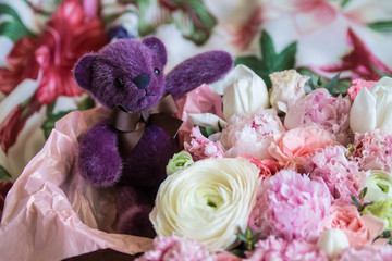 teddy bear in lots of fresh beautiful flowers