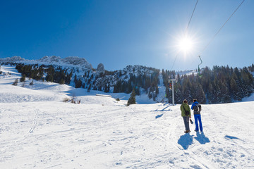 Hiker on the way up to Mountain Kampenwand with chair lift on a sunny winter day