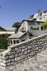 Ancient buildings on the riverside of old kriva cuprija bridge in Mostar