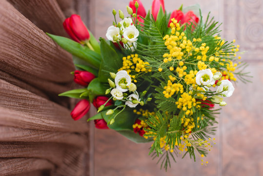 Still-life is a flower gift to your beloved. Decorative design floral bouquet of tulips and mimosa . Selective focus