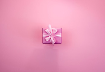 Decorative festive gift box with pink color on pink background.