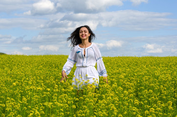 beautiful young girl in a white dress in a field of flowers