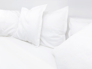 Fototapeta na wymiar Few white pillows on bed. Clear white bed linen for restful sleep.