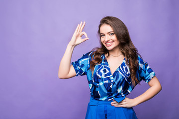 Attractive lady given okay sign isolated on purple background