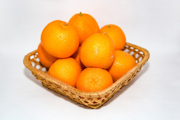 Few appetizing orange mandarins in a wicker basket
