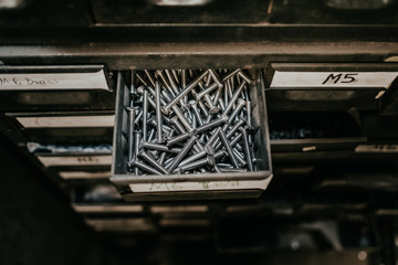 a film cenamatic style looking of nails organized by a big metal drawers