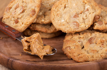 Pile of peanut butter cookies and a spoonful of peanut butter