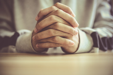 Man praying on a wooden table