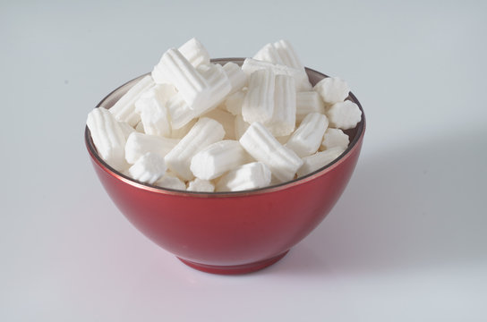 A red plate wit marshmallows on a white background. Close up. Christmas photo. 