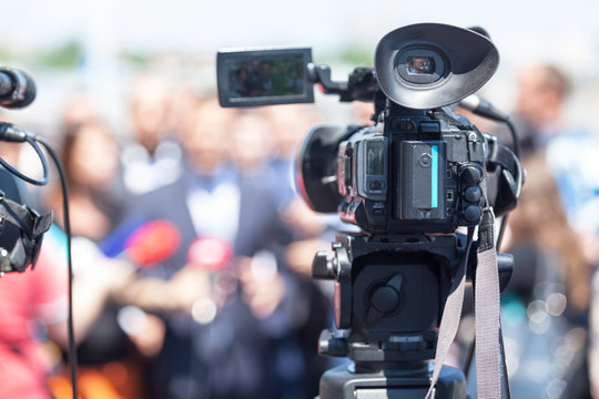 Public relations - PR. Filming an media event with a video camera. News conference.