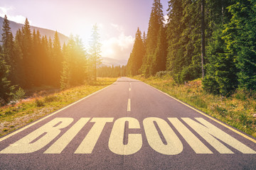 Bitcoin word written on road in the mountains