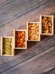 flat lay background dried fruits almonds walnuts cashews pumpkin seeds in wooden boxes on wood background texture top view
