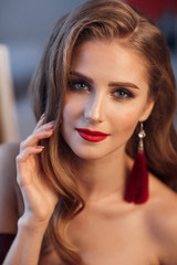 Beautiful sexy lady in an elegant burgundy dress. Close up fashion portrait of model indoors. Beautiful young brunette woman with stylish make-up. Attractive woman in an open dress