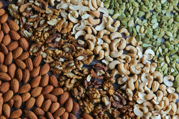 pumpkin seeds, cashew, walnut, almonds, on a wooden background, background texture, view svrhu, benefits, vitamins, still life beautiful, healthy lifestyle, diet, charge for the brain, flat lay