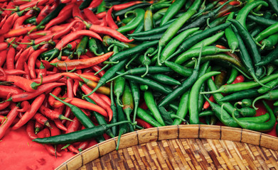 Red and green chili peppers in local Thailand fresh market at a traditional vegetable shop, close up details