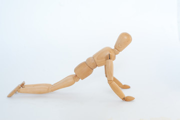 A wooden manicure performs exercises of gymnastics. On a white background.