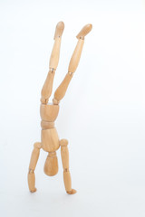 A wooden manicure performs exercises of gymnastics. On a white background.