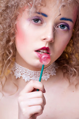 Fototapeta premium Beautiful young blonde with curly hair and creative make-up. Close up.