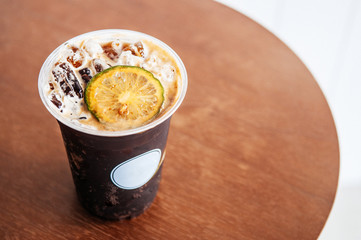 Nitro cold brew or Sparkling espresso soda coffee infuse with lime or lemon in a cup on wooden table