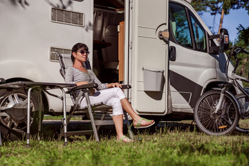 Woman resting near motorhomes in nature. Family vacation travel, holiday trip in motorhome RV, Caravan car Vacation.
