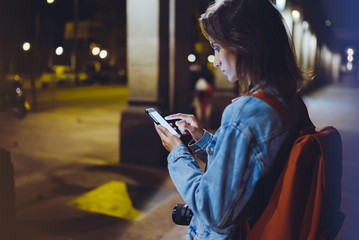 Woman pointing finger on blank screen smartphone on background bokeh light in night atmospheric...