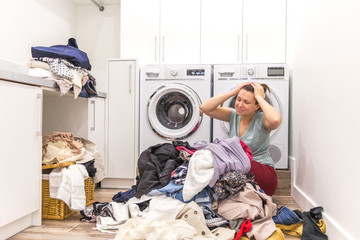 Sad woman sitting in laudry room