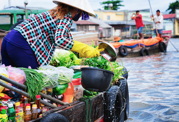 Woman selling fresh vegetables at Floating market in Can Tho