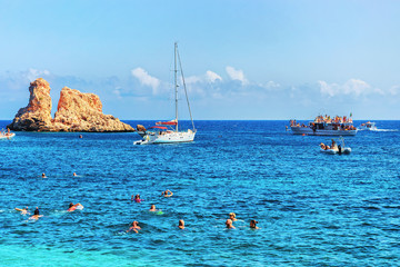 People swimming at beach in Scopello Mediterranean Sea Sicily