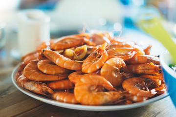 Isolated prepared orange shrimp on background table on kitchen, closeup of fresh prawn products in restaurant, shellfish sea food on plate, group cooked boiled seafood, ocean dieting shrimps