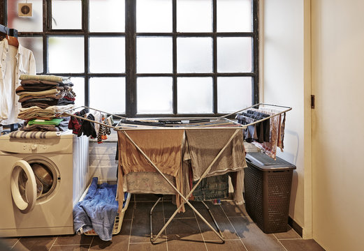 Untidy And Messy Male Laundry Room Against Windows