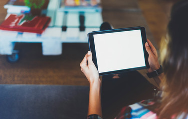 Hipster girl using tablet technology in home, blogger girl person holding computer with blank screen on background bokeh, female hands texting on relax holiday, mockup templates gadget