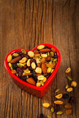 Energy Blend Trail Mix with Nuts and Dried Fruits in Heart Shaped Bowl. Selective focus.