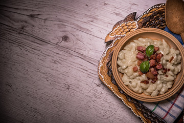 Slovak traditional dishes, potato gnocchi, bryndza, on wooden pancakes, potatoes, eggs. milk, sheep's cheese