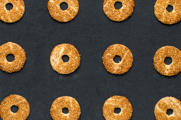 Round cookies with sesame seeds on a black background. Confectionery product.