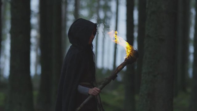 Woman walking in the forest with a torch