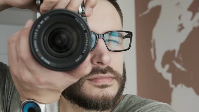Photographer takes pictures with pro camera. Close up handsome man taking pictures with professional camera