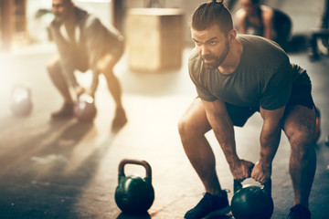 Man lifting dumbbells during a workout class at the gym