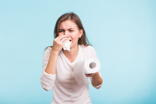 Young Man Has A Runny Nose On Blue Background