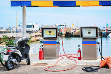 Motorcycle at petrol station for filling ships Cefalu port Sicily