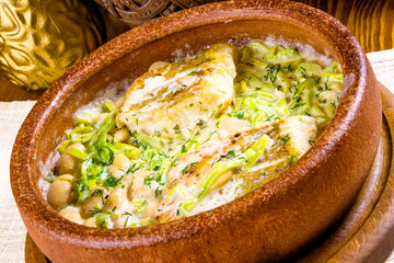 Pikeperch baked with beans and leek in clay pot