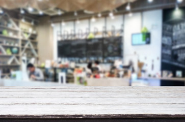 Selected focus empty brown wooden table and Coffee shop or restaurant blur background with bokeh image. for your photomontage or product display.