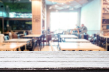 Selected focus empty brown wooden table and Coffee shop or restaurant blur background with bokeh image. for your photomontage or product display.