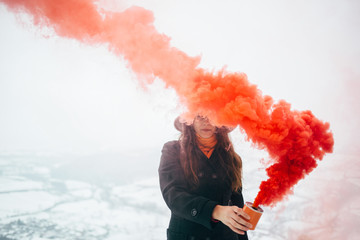 Hipster girl with red smoke bomb send smoke signal - obrazy, fototapety, plakaty