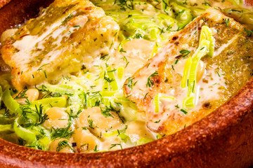 Pikeperch baked with beans and leek in clay pot