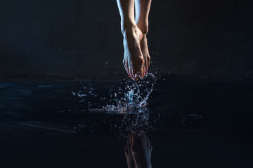 Woman jumping in water barefoot cropped shot